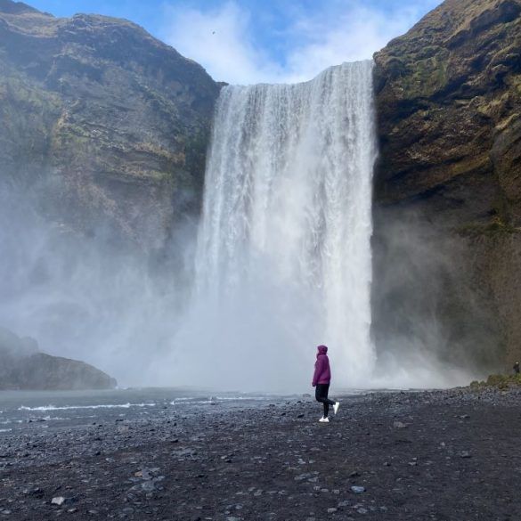 cascada y persona delante caminando hacia la izquierda