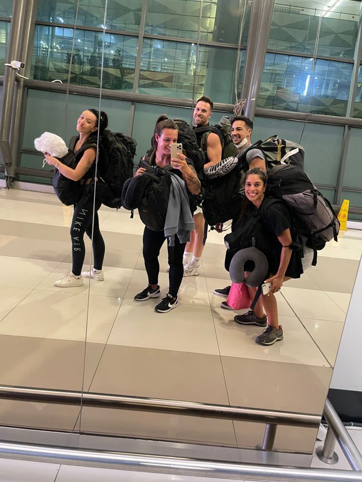 ruta por indonesia posando en el aeropuerto en un espejo 5 jovenes con maleta en la espalda de viaje