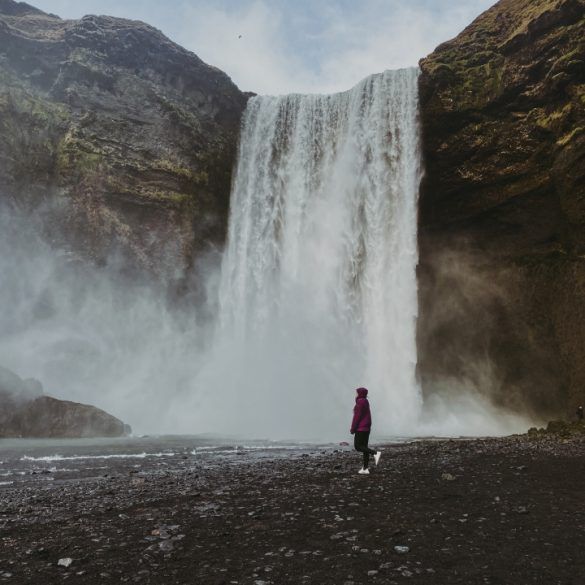cascada y persona delante caminando hacia la izquierda
