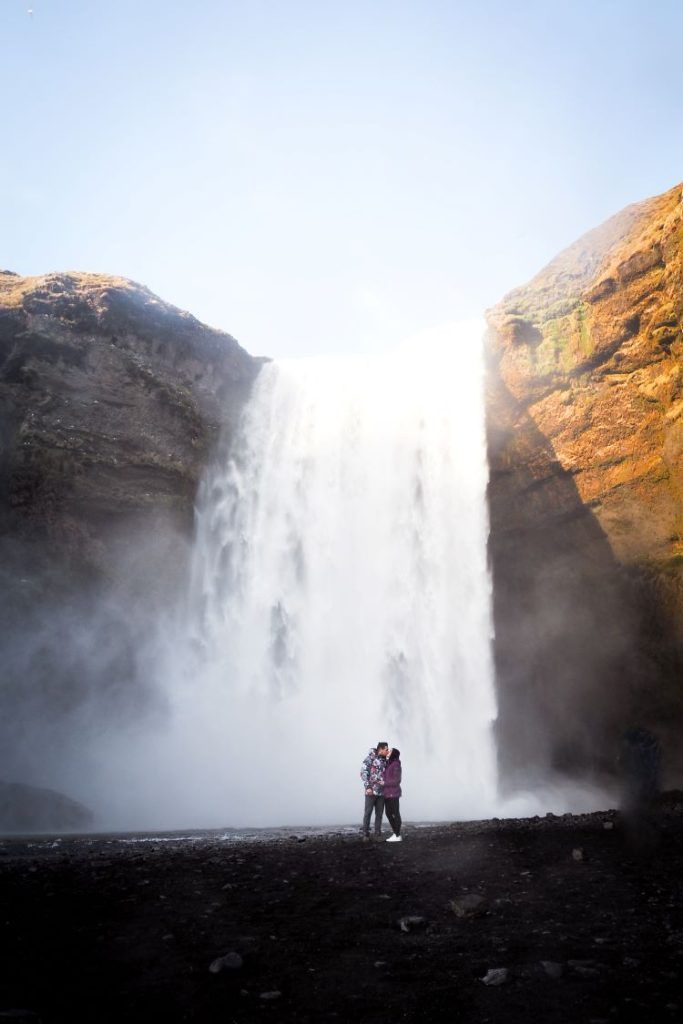 cascada vista de frente con dos personas besándose delante de la cascada