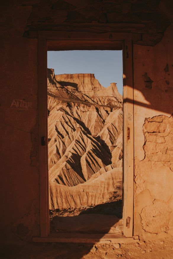 marco de puerta abandonada y dentro de el se ven montañas deserticas