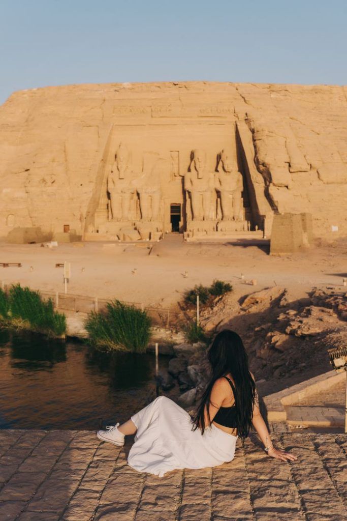 templo de fondo y chica sentada en en el suelo de espaldas mirando el templo