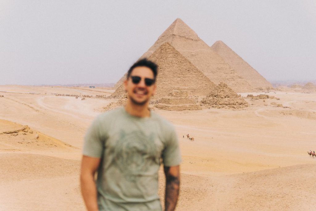 chico sonriendo de frente y pirámides de Egipto de fondo