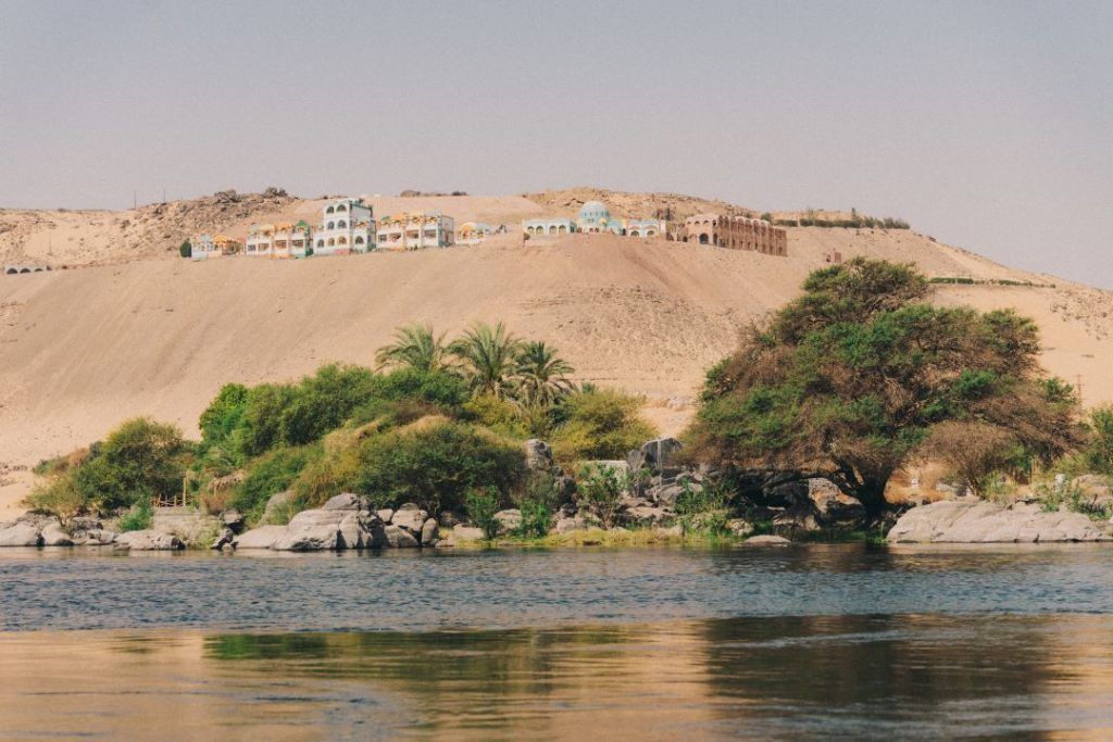 rio y montaña de fondo con pueblo de casas blancas hechas con barro