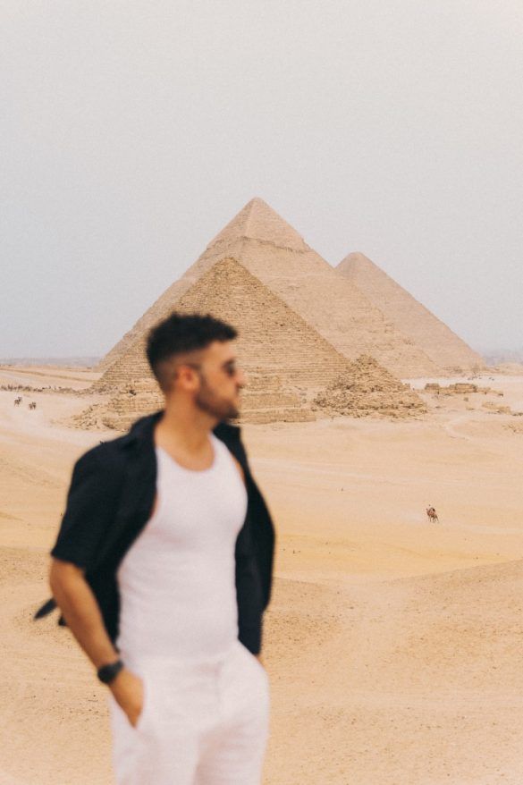 chico mirando hacia la derecha y pirámides de Egipto de fondo